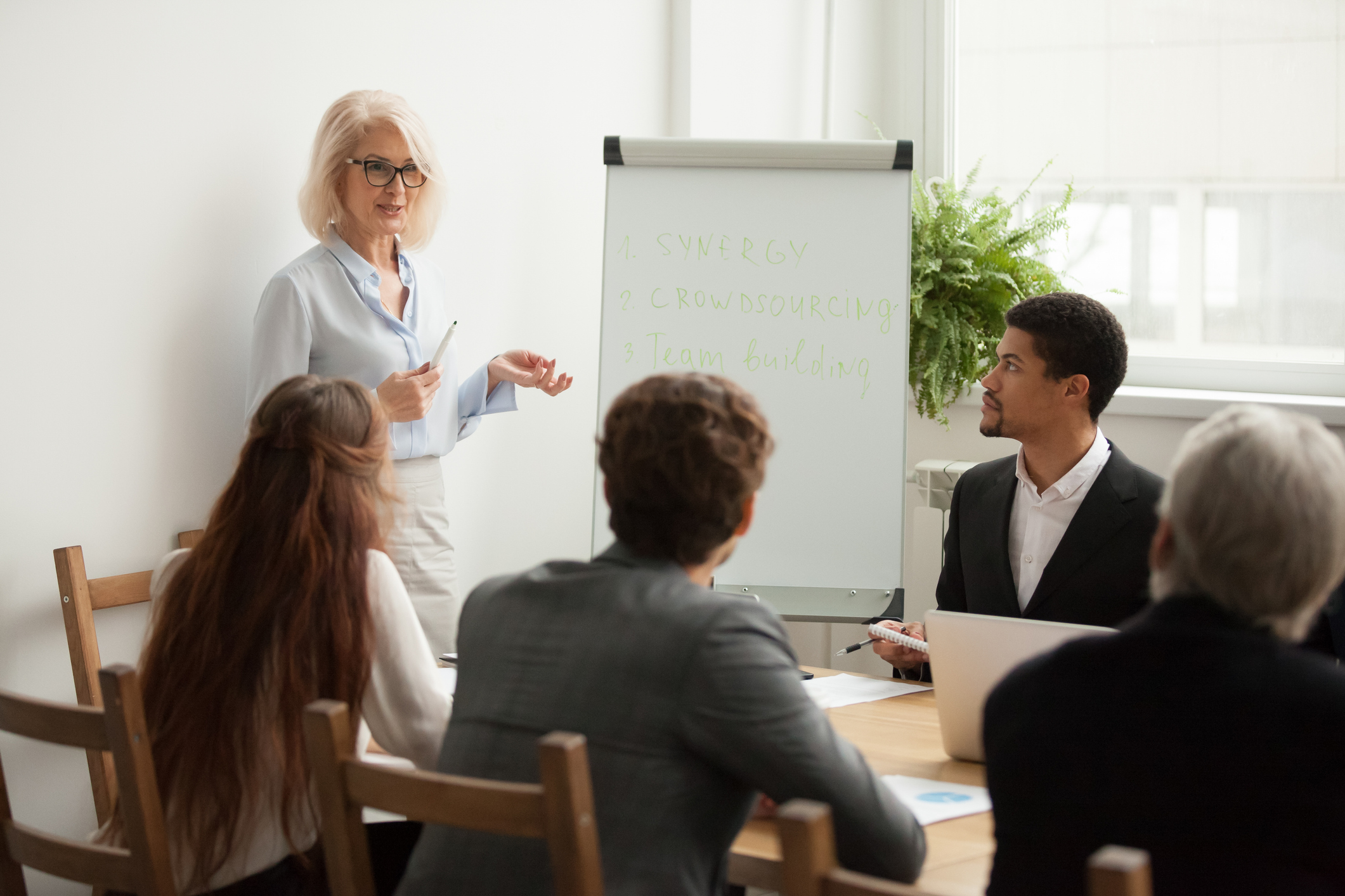 businesswoman giving presentation at corporate team meeting